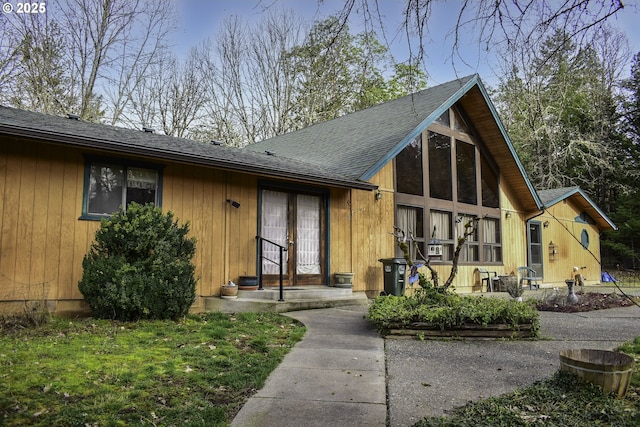 view of front of property with french doors and roof with shingles