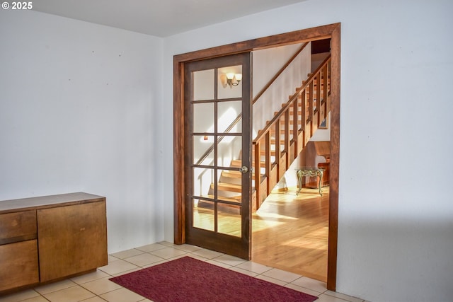 doorway to outside with stairway and tile patterned floors