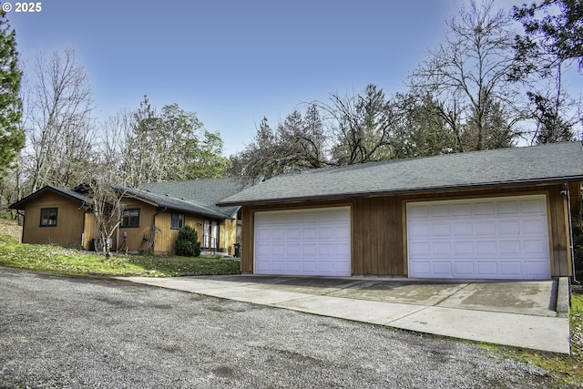 ranch-style home with roof with shingles and an outbuilding