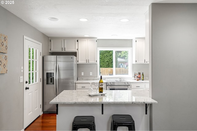4782 Lowell Ave, Keizer, OR 97303 - kitchen featuring stainless steel appliances, a breakfast bar area, healthy amount of natural light, light stone countertops, and recessed lighting