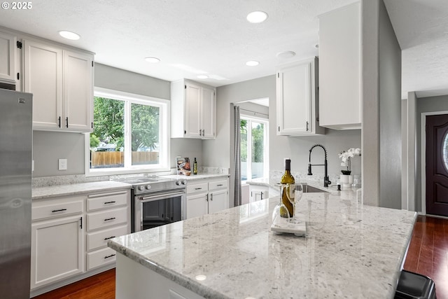 4782 Lowell Ave, Keizer, OR 97303 - kitchen with stainless steel appliances, light stone counters, dark wood-style flooring, white cabinets, and a textured ceiling