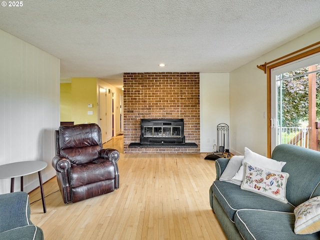 13601 S Union Hall Rd, Canby, OR 97013 - living area with hardwood / wood-style floors, a textured ceiling, a brick fireplace, and baseboards