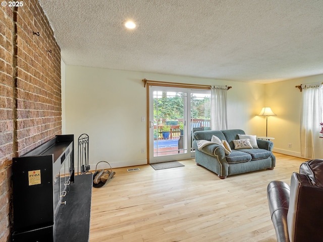13601 S Union Hall Rd, Canby, OR 97013 - living room with a textured ceiling, wood finished floors, and brick wall