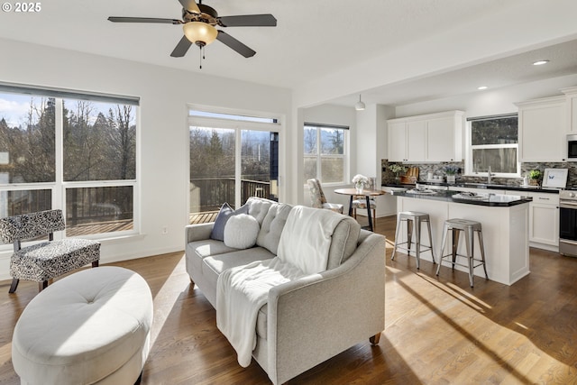 living room with sink, dark wood-type flooring, and ceiling fan