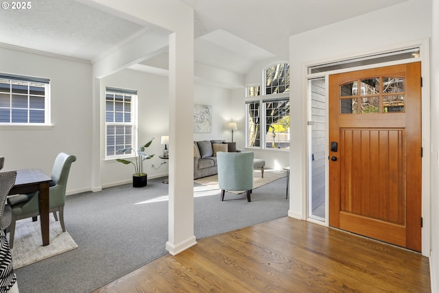 foyer entrance featuring wood-type flooring, a textured ceiling, and crown molding