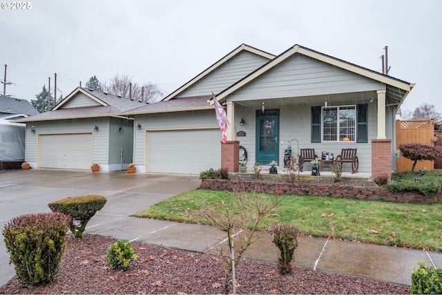 view of front of property featuring a porch, concrete driveway, and a garage