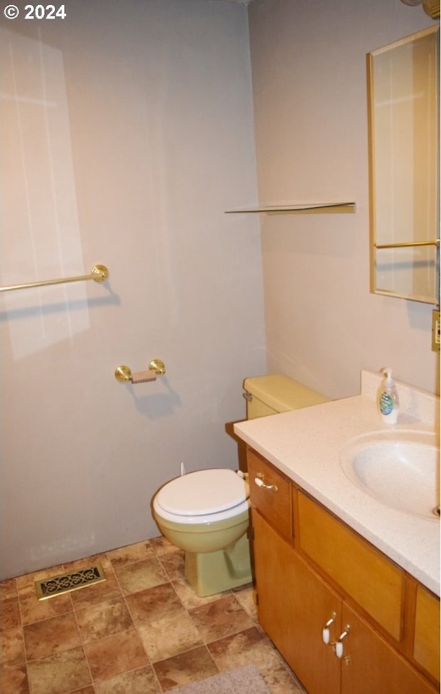 half bath with vanity, visible vents, and toilet