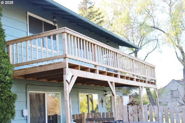 back of property with fence and a wooden deck