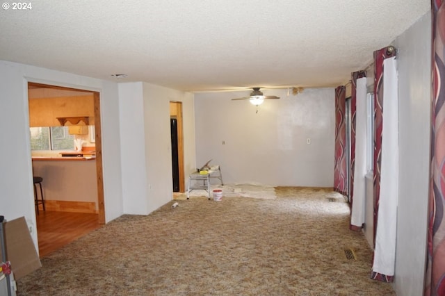 unfurnished room featuring carpet flooring, a textured ceiling, and ceiling fan