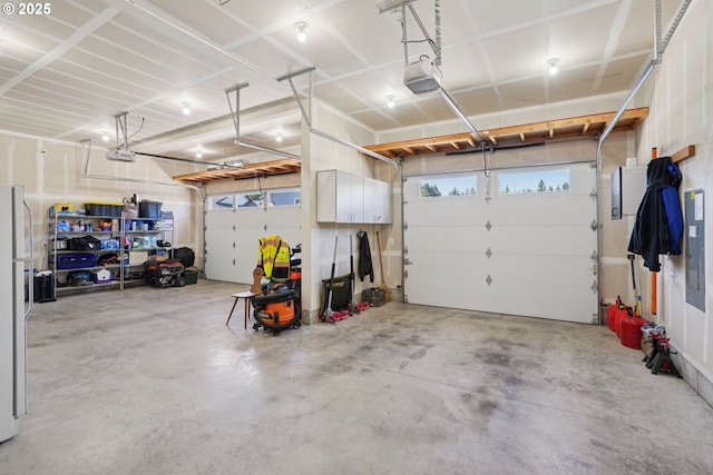 219 W Christy Ct, Yacolt, WA 98675 - garage featuring a garage door opener and freestanding refrigerator