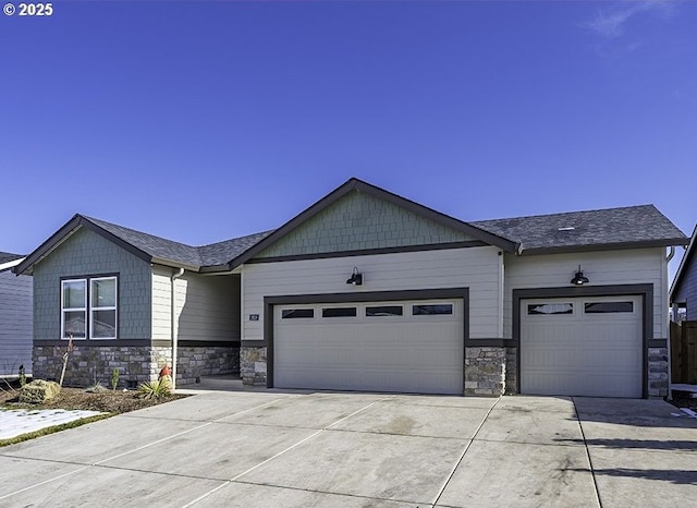 view of front of house featuring a garage, concrete driveway, and stone siding