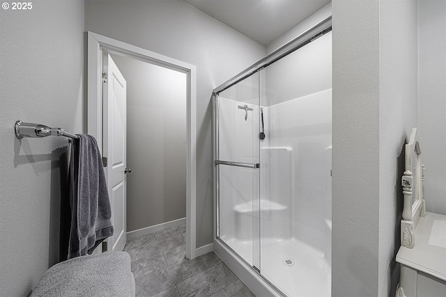 full bathroom featuring a stall shower and baseboards