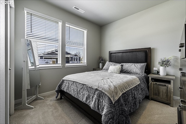 bedroom featuring light carpet, visible vents, and baseboards