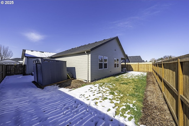 back of house with a storage unit, an outdoor structure, and a fenced backyard