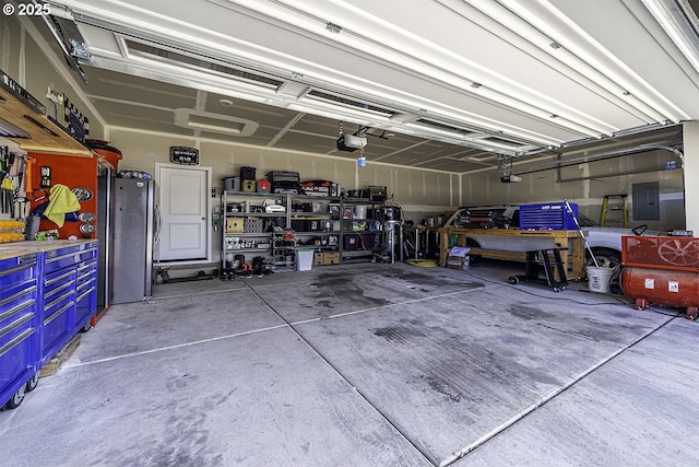 garage with electric panel, freestanding refrigerator, and a garage door opener