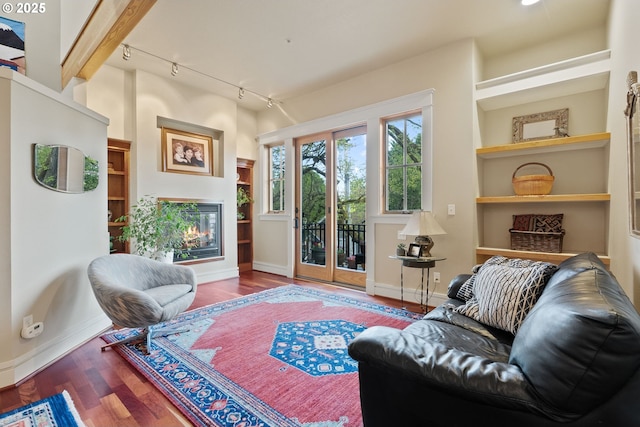living room with baseboards, track lighting, and wood finished floors
