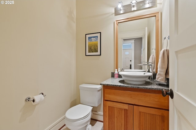 half bathroom with vanity and toilet