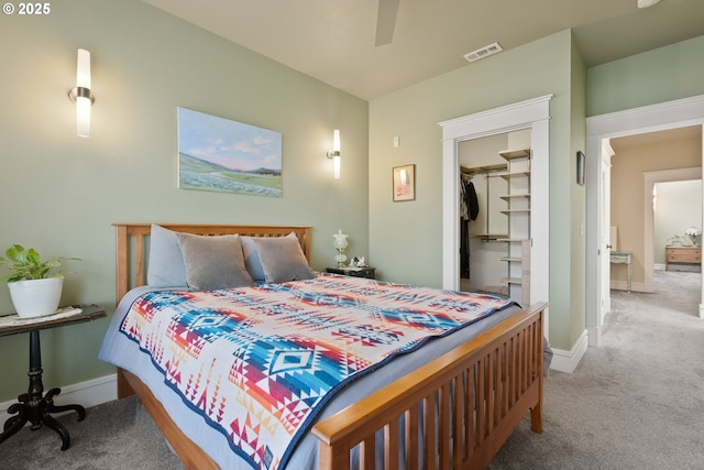 carpeted bedroom with baseboards, ceiling fan, a spacious closet, and visible vents