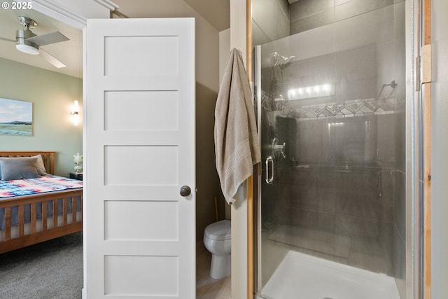 ensuite bathroom with a stall shower, connected bathroom, toilet, and a ceiling fan
