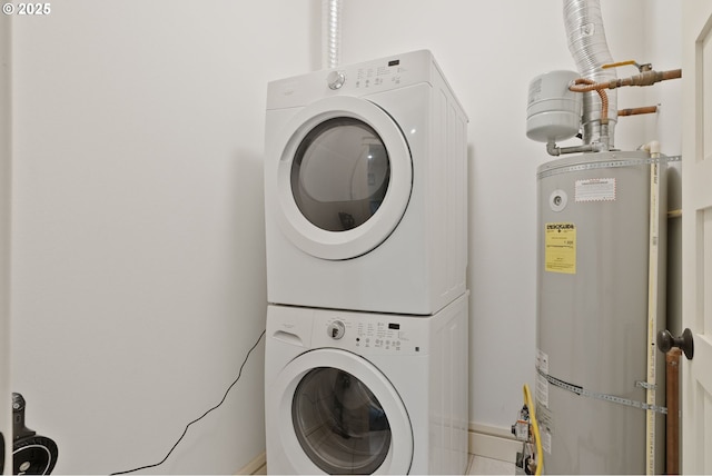 clothes washing area featuring laundry area, stacked washer and clothes dryer, and water heater