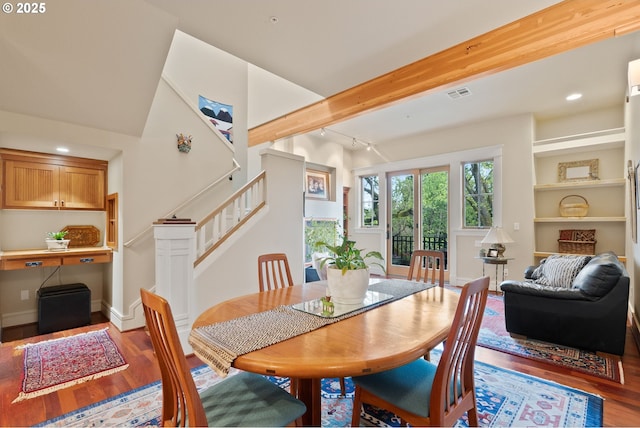 dining space featuring stairs, visible vents, and wood finished floors