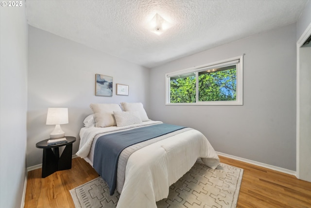 7323 SW Nevada Ter, Portland, OR 97219 - bedroom featuring a textured ceiling and light wood finished floors