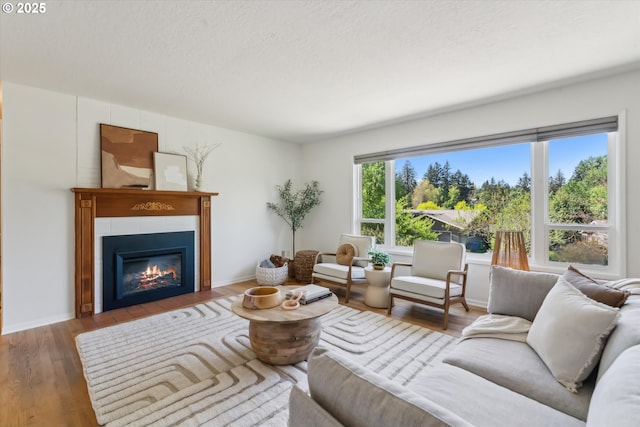 7323 SW Nevada Ter, Portland, OR 97219 - living area featuring wood finished floors, a tile fireplace, and a textured ceiling
