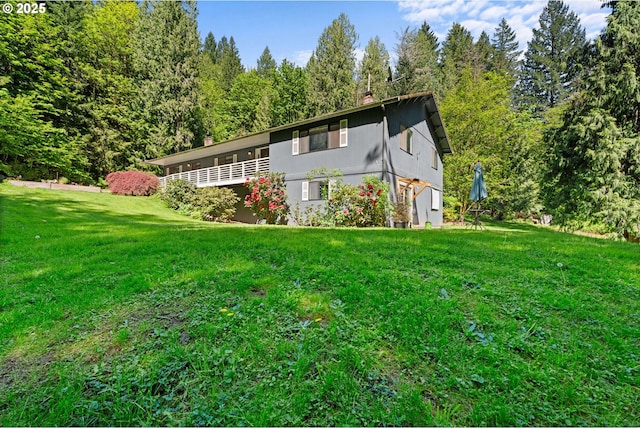 back of property featuring a chimney and a lawn