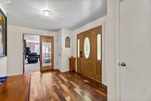 entryway featuring dark wood finished floors, a textured ceiling, baseboards, and french doors