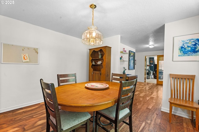 dining room with wood finished floors, a chandelier, baseboards, and a textured ceiling