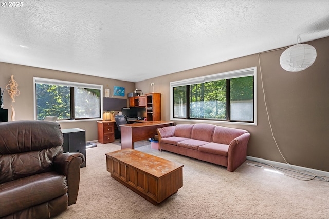 living room with plenty of natural light, a textured ceiling, light carpet, and a desk