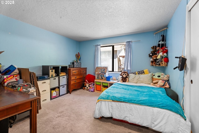 bedroom with a textured ceiling, light carpet, and an office area