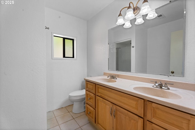 bathroom with tile patterned floors, toilet, double vanity, and a shower