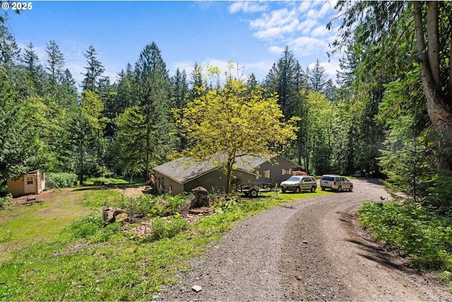 view of dirt / gravel road featuring a forest view