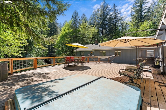 deck featuring outdoor dining area and view of scattered trees