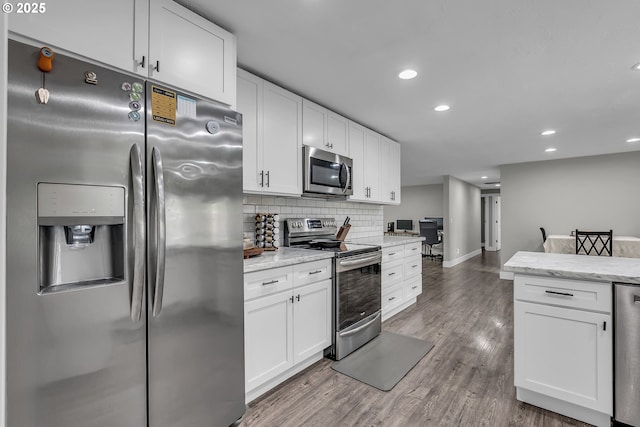 1388 Hillendale Dr, Salem, OR 97302 - kitchen featuring appliances with stainless steel finishes, white cabinets, decorative backsplash, wood finished floors, and recessed lighting