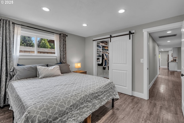 1388 Hillendale Dr, Salem, OR 97302 - bedroom featuring wood finished floors, recessed lighting, a barn door, and a closet