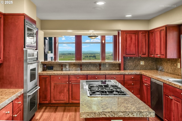 45585 NW David Hill Rd, Forest Grove, OR 97116 - kitchen featuring stainless steel appliances, dark brown cabinets, light wood-type flooring, light countertops, and tasteful backsplash