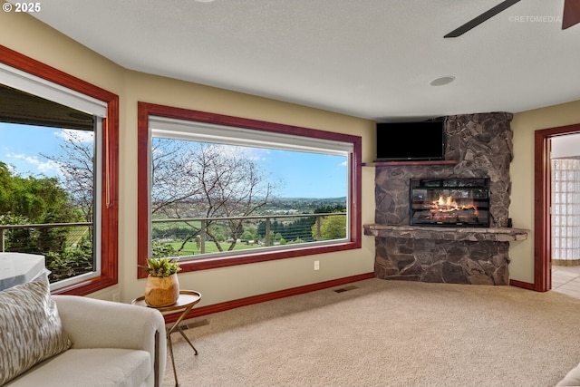 45585 NW David Hill Rd, Forest Grove, OR 97116 - living room featuring a stone fireplace, carpet, a ceiling fan, and baseboards