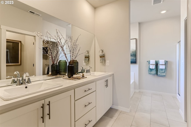 bathroom featuring a garden tub, double vanity, a sink, and visible vents