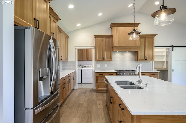 kitchen featuring a barn door, stainless steel fridge, tasteful backsplash, decorative light fixtures, and lofted ceiling