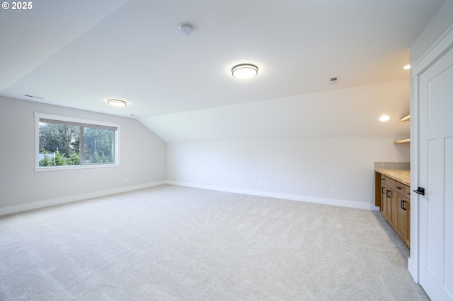 additional living space with light carpet and lofted ceiling