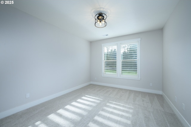 spare room featuring light carpet