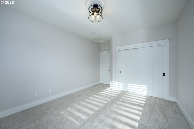 unfurnished bedroom with a closet and light colored carpet