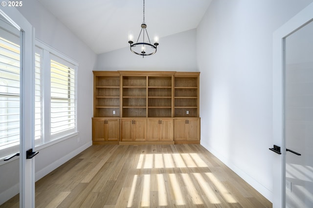 interior space featuring vaulted ceiling, an inviting chandelier, and light hardwood / wood-style floors