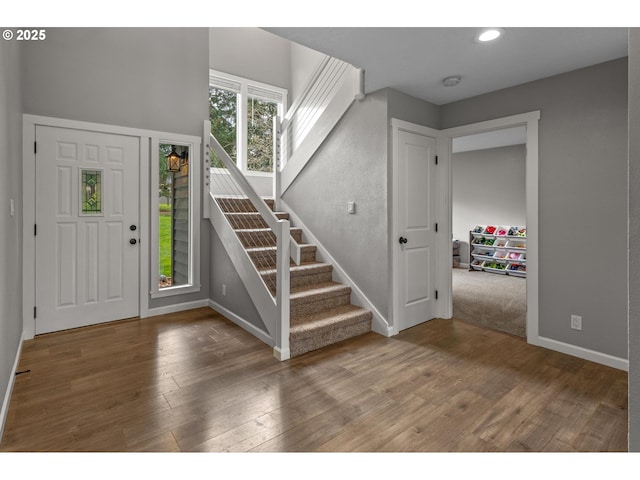 foyer with recessed lighting, baseboards, stairs, and wood finished floors