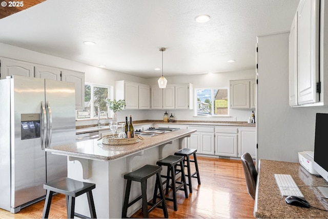 2395 88th Ave NE, Salem, OR 97305 - kitchen with appliances with stainless steel finishes, healthy amount of natural light, a kitchen breakfast bar, white cabinets, and recessed lighting
