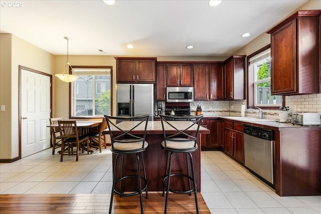 810 E 9th St Unit E18, Newberg, OR 97132 - kitchen featuring appliances with stainless steel finishes, decorative backsplash, dark brown cabinets, hanging light fixtures, and recessed lighting
