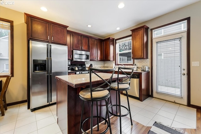 810 E 9th St Unit E18, Newberg, OR 97132 - kitchen featuring stainless steel appliances, backsplash, healthy amount of natural light, a breakfast bar area, and recessed lighting