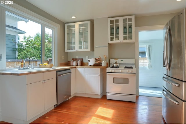 3324 SE Salmon St, Portland, OR 97214 - kitchen with stainless steel appliances, white cabinets, light wood-style floors, light countertops, and recessed lighting